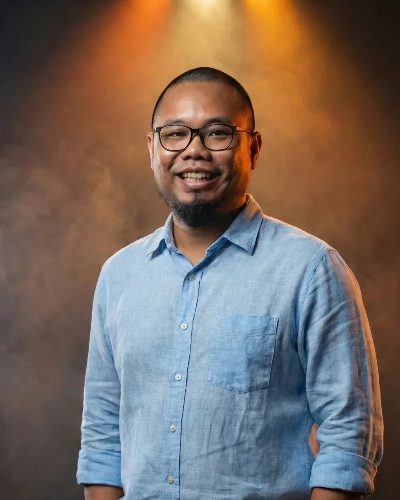 Hizami Radzi berbaju kemeja biru tersenyum